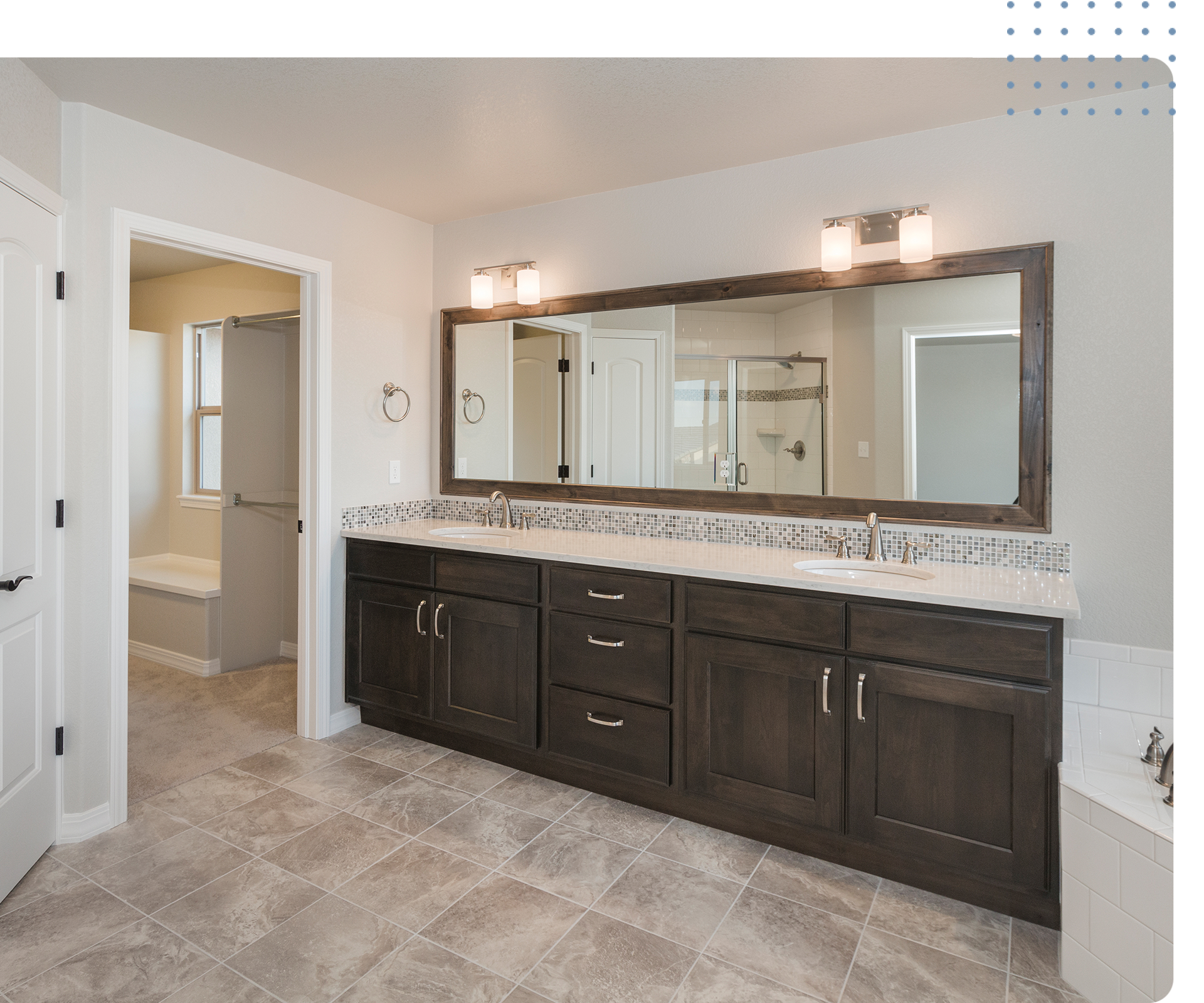 Modern bathroom with dark wood vanity, dual sinks, and large mirror, showcasing clean tile flooring and a well-lit space, emphasizing the importance of maintaining tile and grout surfaces.